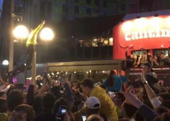 Michigan basketball fans climb streetlights in Ann Arbor after Final Four win against Loyola