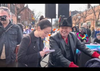 IT'S ANGIE! WATCHING CURTIS PIGNEGUY BEING INTERVIEWED AT THE FESTIFOOLS PARADE, SUNDAY, 4-7-2024.
